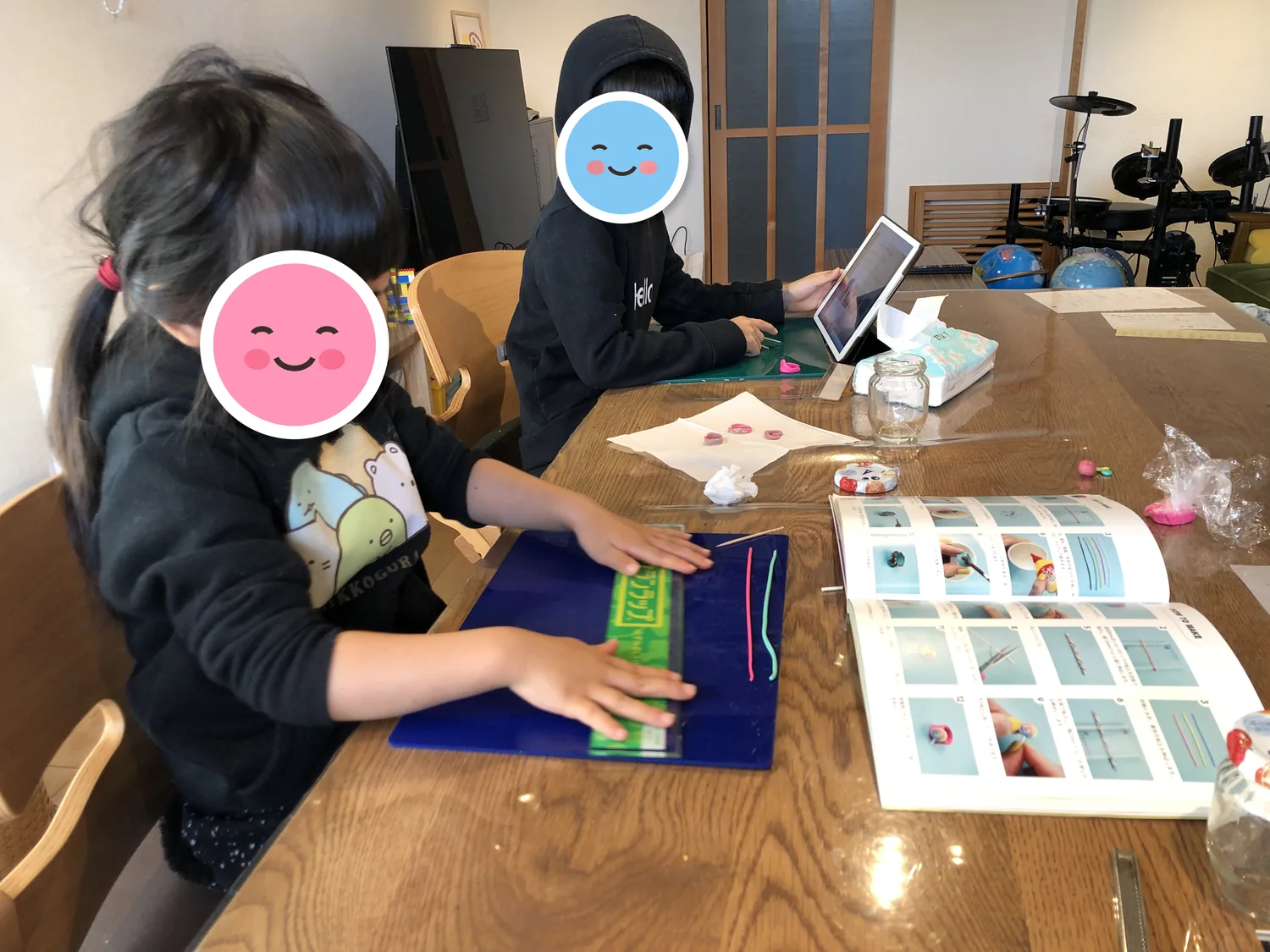 本を見ながら、子供たちと一緒に粘土で指輪を作っているところ
